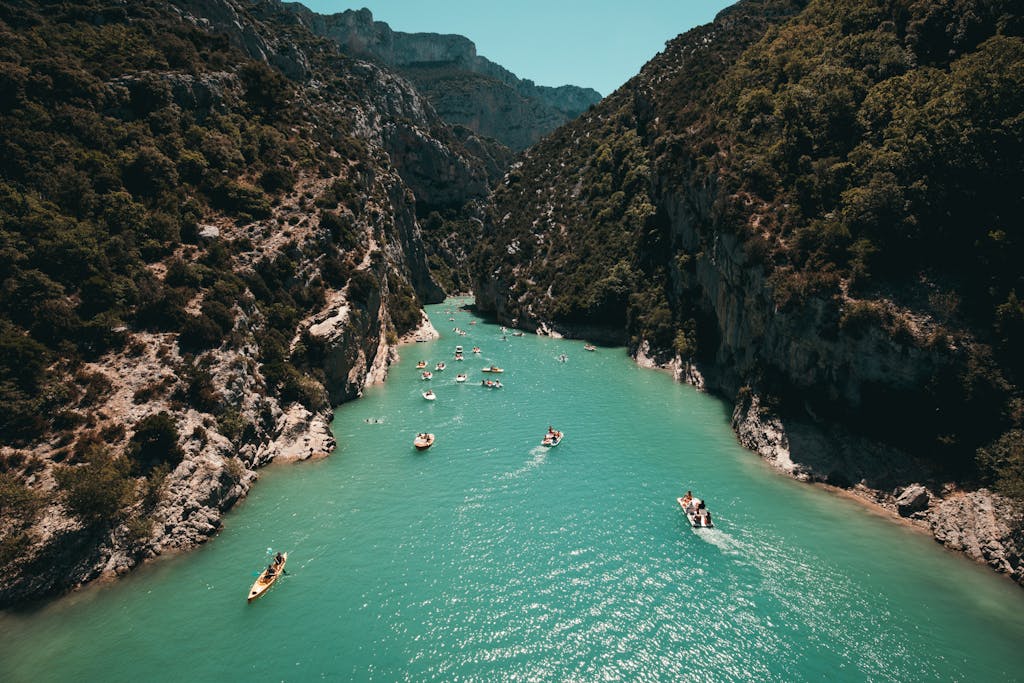 Kayakers enjoy turquoise waters surrounded by lush canyon walls—the perfect setting for an adventure.